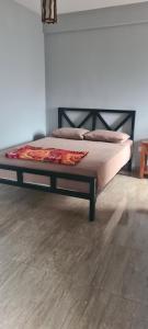 a bed in a room with a wooden floor at Ramboda Rest in Nuwara Eliya