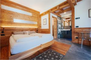 ein Schlafzimmer mit einem großen Bett in einem Zimmer mit Holzwänden in der Unterkunft Agritur Golden Pause in Ton
