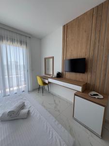 a bedroom with a bed and a desk with a television at Morea Residence in Ulcinj