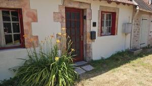 a house with a red door and a plant at Maison du golf in Nassigny