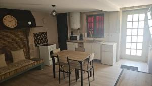 a kitchen with a table and chairs and a clock at Maison du golf in Nassigny