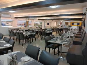 a dining room with tables and chairs and a restaurant at Downtown Business Hotel in Singapperumālkovil +10 photos