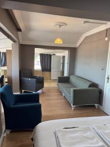 a living room with a couch and two chairs at Kalmuk Apartment Hotel in Trabzon