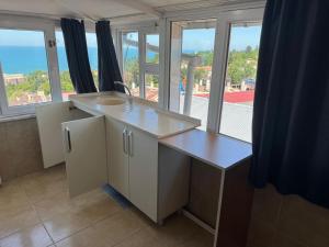 a kitchen with a counter and a large window at Kalmuk Apartment Hotel in Trabzon