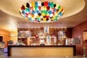 um grande lustre colorido pendurado no tecto num átrio em Base Hotel em Noventa di Piave