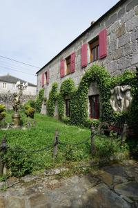 an ivycovered building with red doors and windows at Casa de San Pedro de Cerceda in Villasante