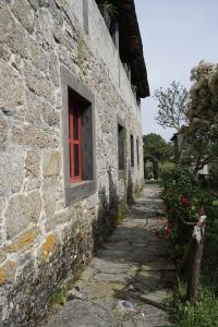 a stone building with a red window on it at Casa de San Pedro de Cerceda in Villasante +7 photos