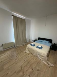 a bedroom with a bed and a wooden floor at 1 Grande Chambre Frigo privé in Charleroi