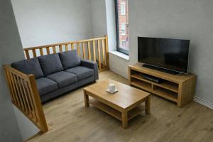 a living room with a couch and a tv at 1 Grande Chambre Frigo privé in Charleroi