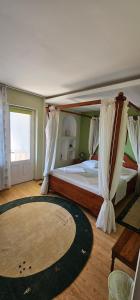 a bedroom with a canopy bed with a rug at Casa Belu in Eforie Nord