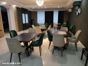 a dining room with tables and green chairs at Telavi ERMA in Telavi