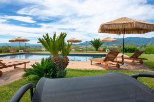 a pool with two chairs and umbrellas next to at Il Nido del Falco in Montefalco