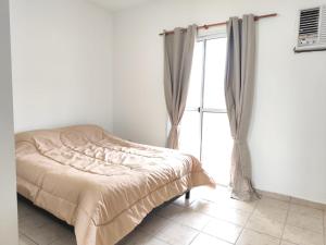 a bed in a white room with a window at Destino Wilde in Resistencia