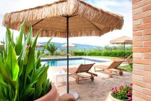 a patio with two chairs and a large umbrella at Il Nido del Falco in Montefalco