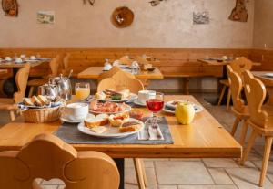 ein Tisch mit Tellern voller Speisen und Gläsern Wein in der Unterkunft Agritur Golden Pause in Ton