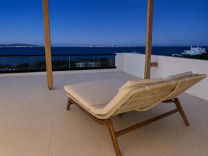 a bed on a balcony with a view of the ocean at Syros-house in Azolimnos Syros