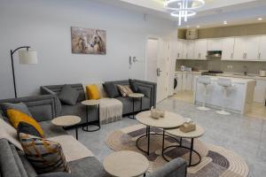 a living room with a couch and tables and a kitchen at The view apartment 2 in Al Baha