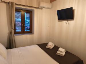 a bedroom with a bed with two towels at Tsitsinos Village Cottage in Zekros