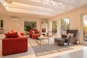 a living room with red furniture and large windows at Stay North - Merimaa in Tallbacka