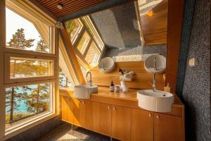 a bathroom with two sinks and two mirrors at Stay North - Merimaa in Tallbacka +50 photos