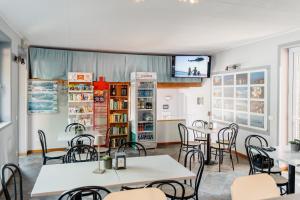 a restaurant with tables and chairs and a tv at Campeggio Tranquilla in Baveno