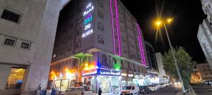 a building with a neon sign on the side of it at Zad Al Hayat in Mecca