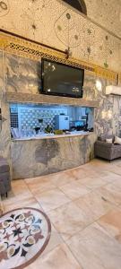 a living room with a tv on a stone wall at Zad Al Hayat in Mecca