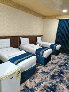a hotel room with three beds in a room at Zad Al Hayat in Mecca