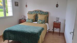 a bedroom with a bed with a green comforter at gîte de bon air in Sens-de-Bretagne
