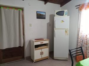 a kitchen with a refrigerator and a small table at Las Grutas Centro alojamiento in Las Grutas
