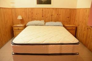 a large bed in a room with two night stands and a bed sidx sidx sidx at Las Grutas Centro alojamiento in Las Grutas