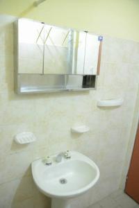 a bathroom with a sink and a mirror at Las Grutas Centro alojamiento in Las Grutas +1 photo
