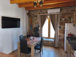 a dining room with a table and chairs and a window at Tsitsinos Village Cottage in Zekros