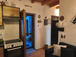 a kitchen with a stove and a living room at Tsitsinos Village Cottage in Zekros