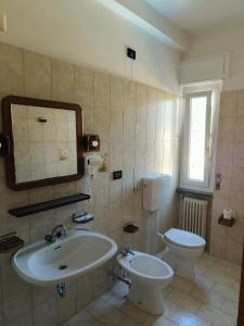 a bathroom with a sink and a toilet and a mirror at Albergo Drena in Drena +24 photos