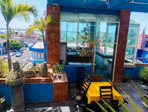 a yellow table in front of a building with palm trees at Hotel Magico del Mar in La Paz
