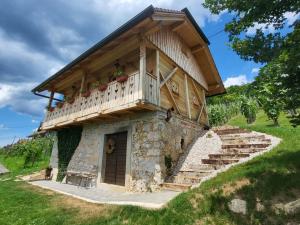 a house with a balcony on top of it at Oddih v Srčni hiški in Dvor