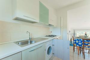a kitchen with a sink and a washing machine at Chic Residence Ea Bianca 1 Bed Apartment sleeps 4 in Cala Bitta