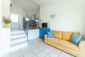 a living room with a couch and a staircase at Chic Residence Ea Bianca 1 Bed Apartment sleeps 4 in Cala Bitta