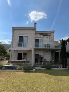 a building with tables and chairs in front of it at Madamik apartments in Bijela