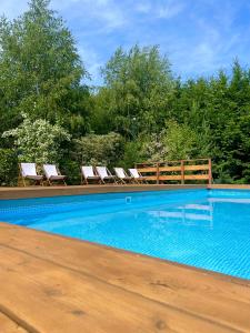 a swimming pool with two chairs and a fence at Pensjonat Zacisze in Czchów