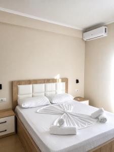 a white bed with white sheets and towels on it at Lukova Center Sunset Apartments in Lukovë