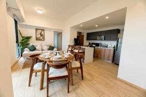 a living room with a table and chairs and a kitchen at Apartamento Moderno z 10-Jacuzzi-Lavandería-AC-Gym-GuatemalaCity in Lo de Contreras