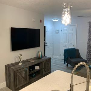 a living room with a flat screen tv on a wall at Villa del Sol Condo,inum in Kissimmee