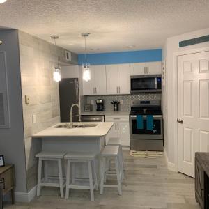 a kitchen with white cabinets and a sink and appliances at Villa del Sol Condo,inum in Kissimmee