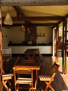 a patio with a table and chairs and a kitchen at Casa Quebec - Apartamentos in São Miguel do Gostoso
