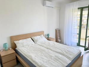 a bedroom with a bed with white sheets and a window at Residence Leonardo sul mare in Silvi Marina