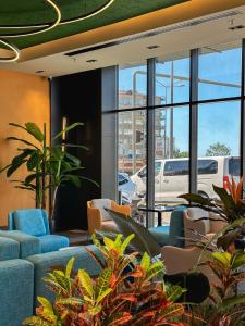 eine Bürolobby mit blauen Stühlen und Pflanzen in der Unterkunft Axis Hotel in Cimenli