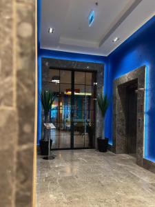 eine Lobby mit blauen Wänden und Topfpflanzen in der Unterkunft Axis Hotel in Cimenli