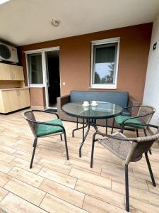 a patio with a table and chairs and a couch at Wellness Dorina in Siófok